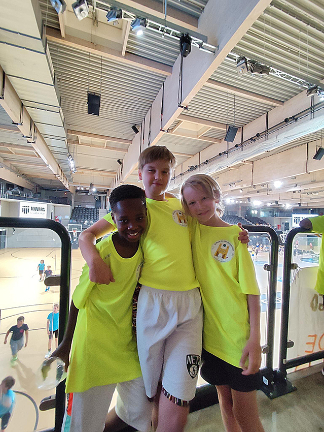 Drei unserer Spieler posieren in der Halle auf der Tribüne.