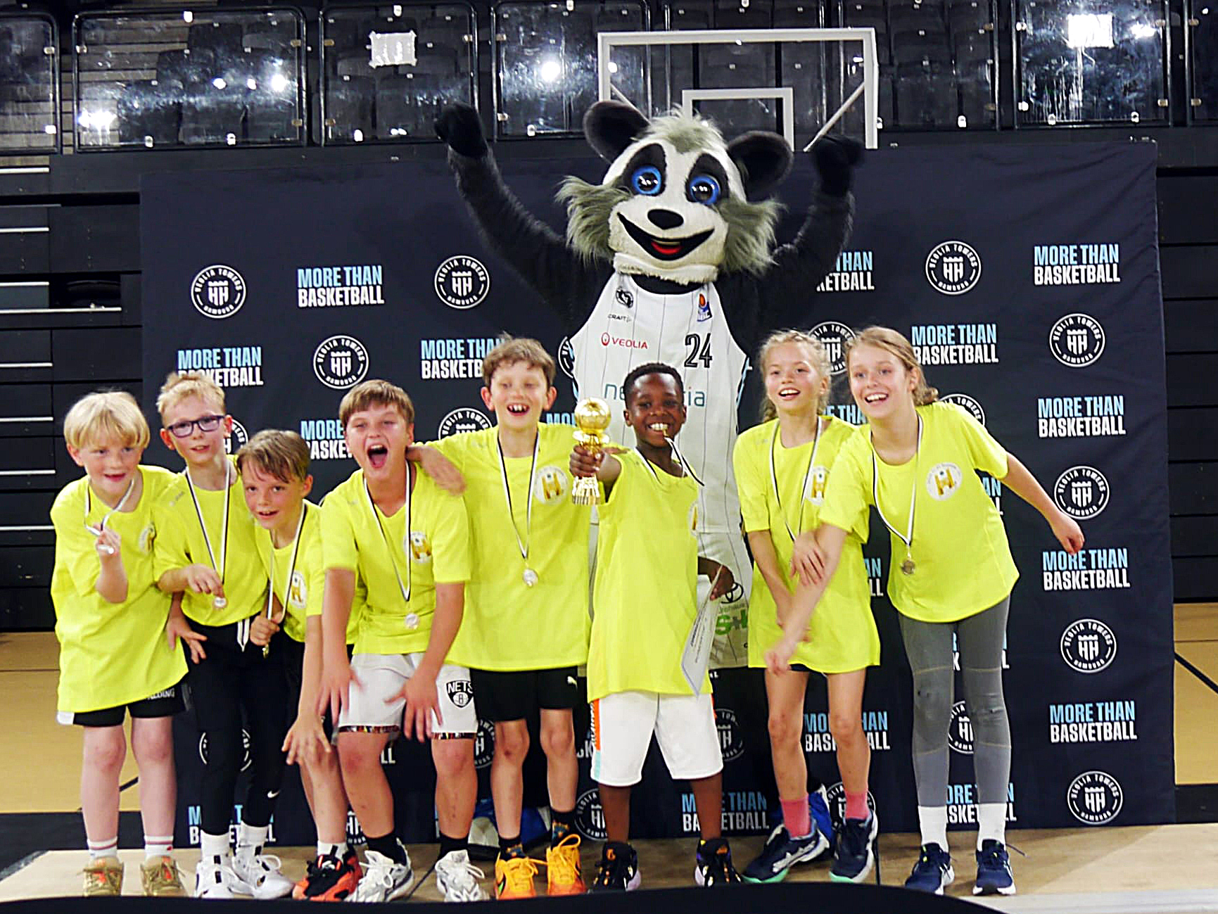 Das Team der Burgweide Baskets I mit dem Pokal und dem Waschbär der Hamburg Towers