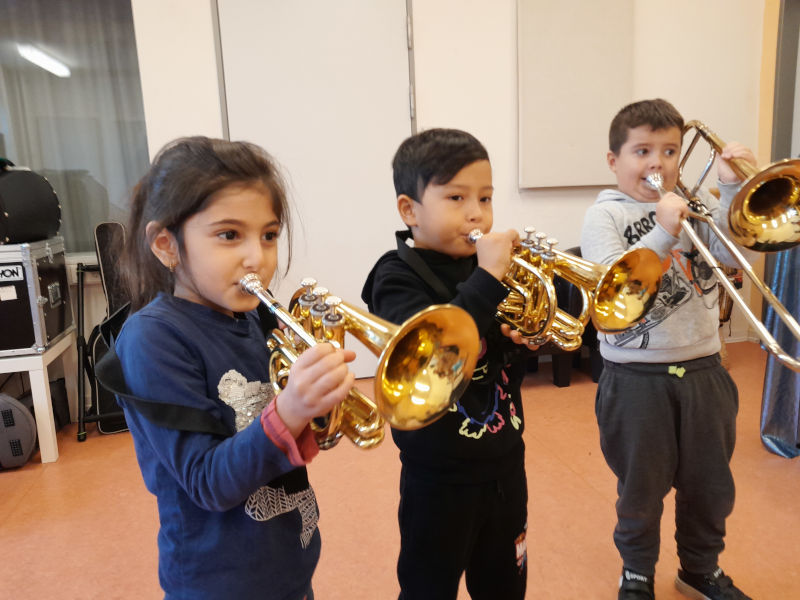 Kinder der Vorschule spielen Blasinstrumente